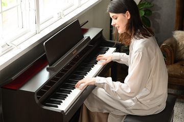 Woman playing the Rosewood Casio AP-550 Digital Piano