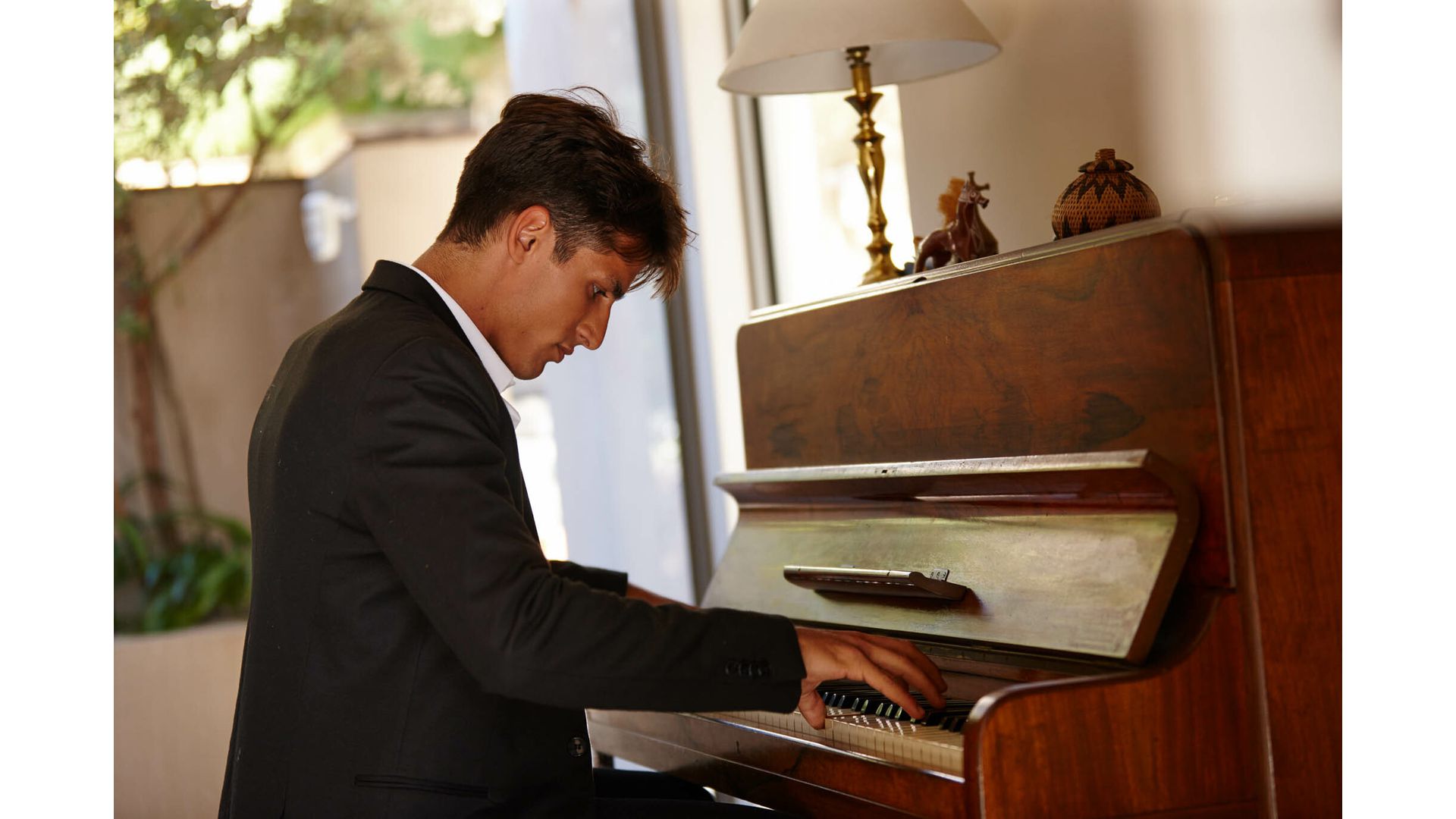 Man playing wooden acoustic piano