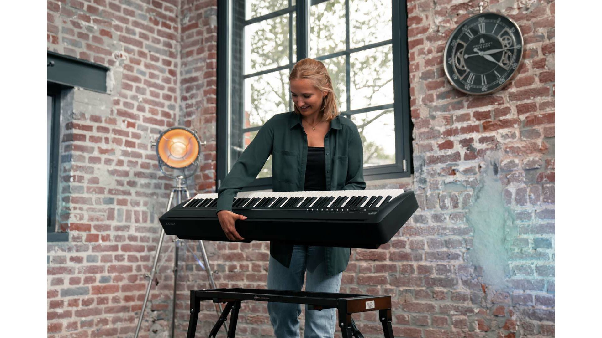 Woman putting Kawai ES120 piano on stand